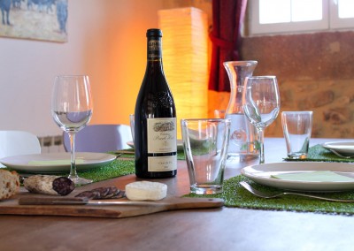 Bouteille de vin, tranches de saussisson, pain et couverts de tables